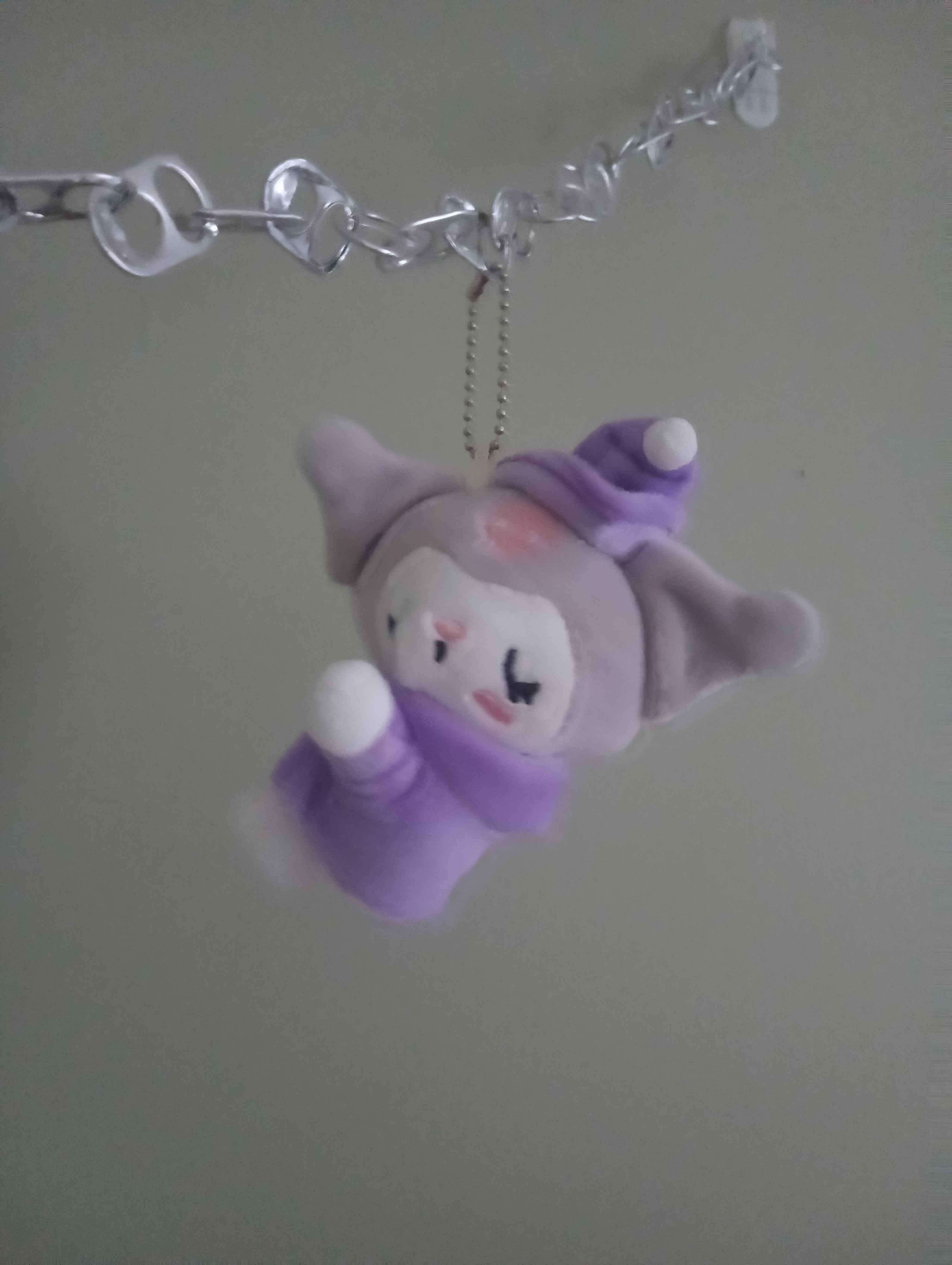 keychain of kuromi sleeping in some ebeneezer scrooge style robes